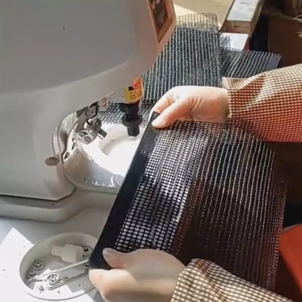Factory workers producing PTFE-coated fiberglass grill bags on customized production line, demonstrating our capability to manufacture tailored sizes and private label products for wholesale clients