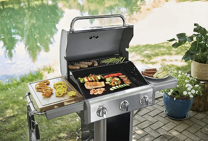 Showcasing the benefits of PTFE grill mat while grilling steak and vegetables outdoors
