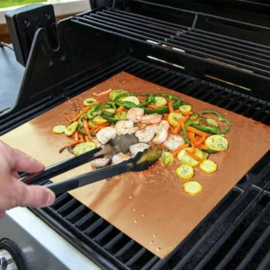 Non-stick copper PTFE bbq grill mat in use for grilling seafood and vegetables