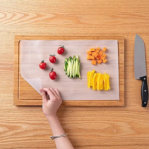 Premium food-grade disposable cutting board mats wholesale roll used in a clean modern kitchen.