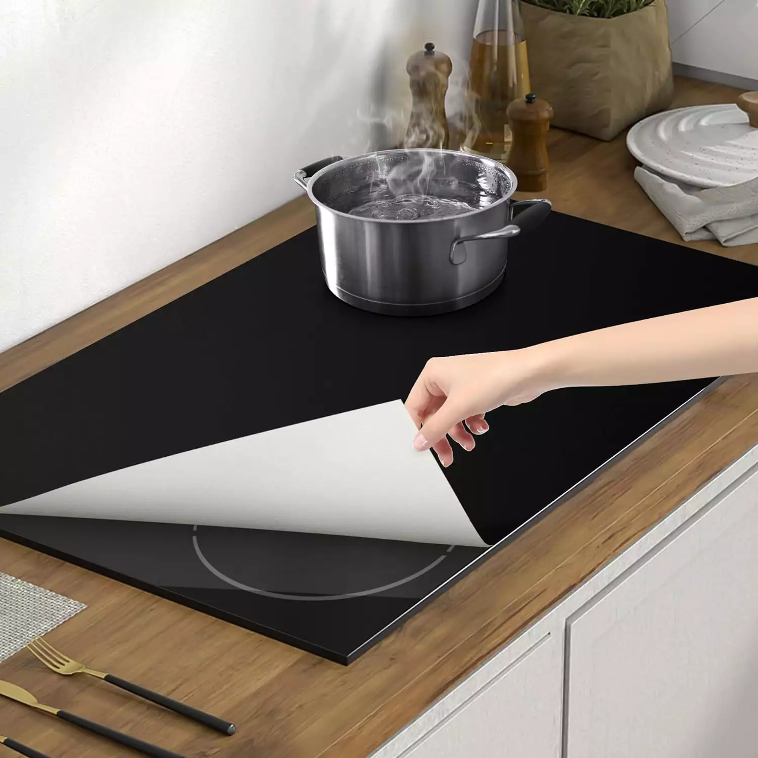 Reversible black and white silicone induction stove liner for minimalist kitchen protection.