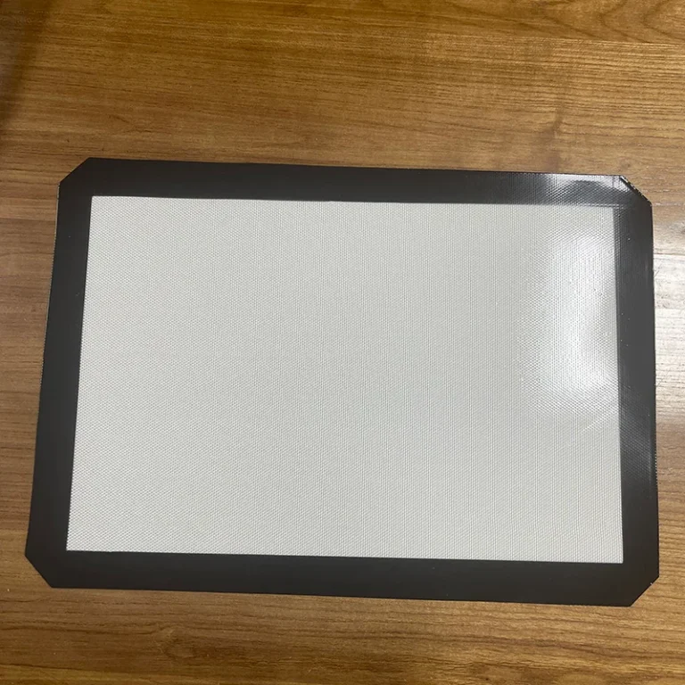 A heavy duty silicone pastry mat wholesale liner flat-laid on a wooden table, showcasing a premium solid woven fiberglass cloth core and non-slip border.